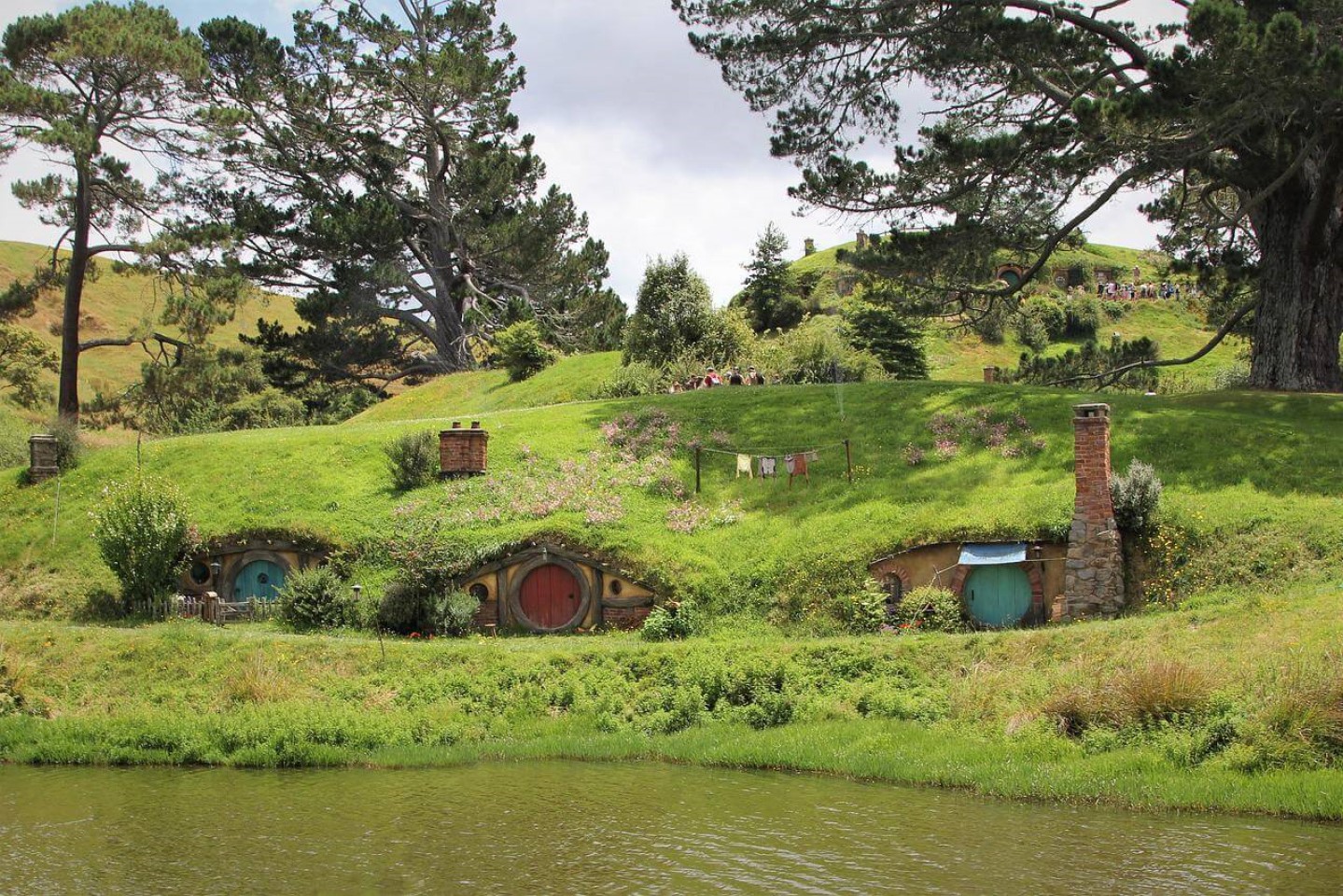 three hobbiton homes lined up on hill